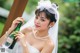 A woman in a wedding dress holding a bottle of champagne.