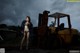 A woman in lingerie standing in front of a forklift.