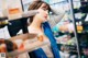 A woman standing in front of a refrigerator in a grocery store.